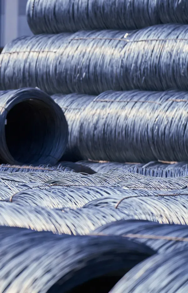 Stacked coils of raw steel wire in a materials yard