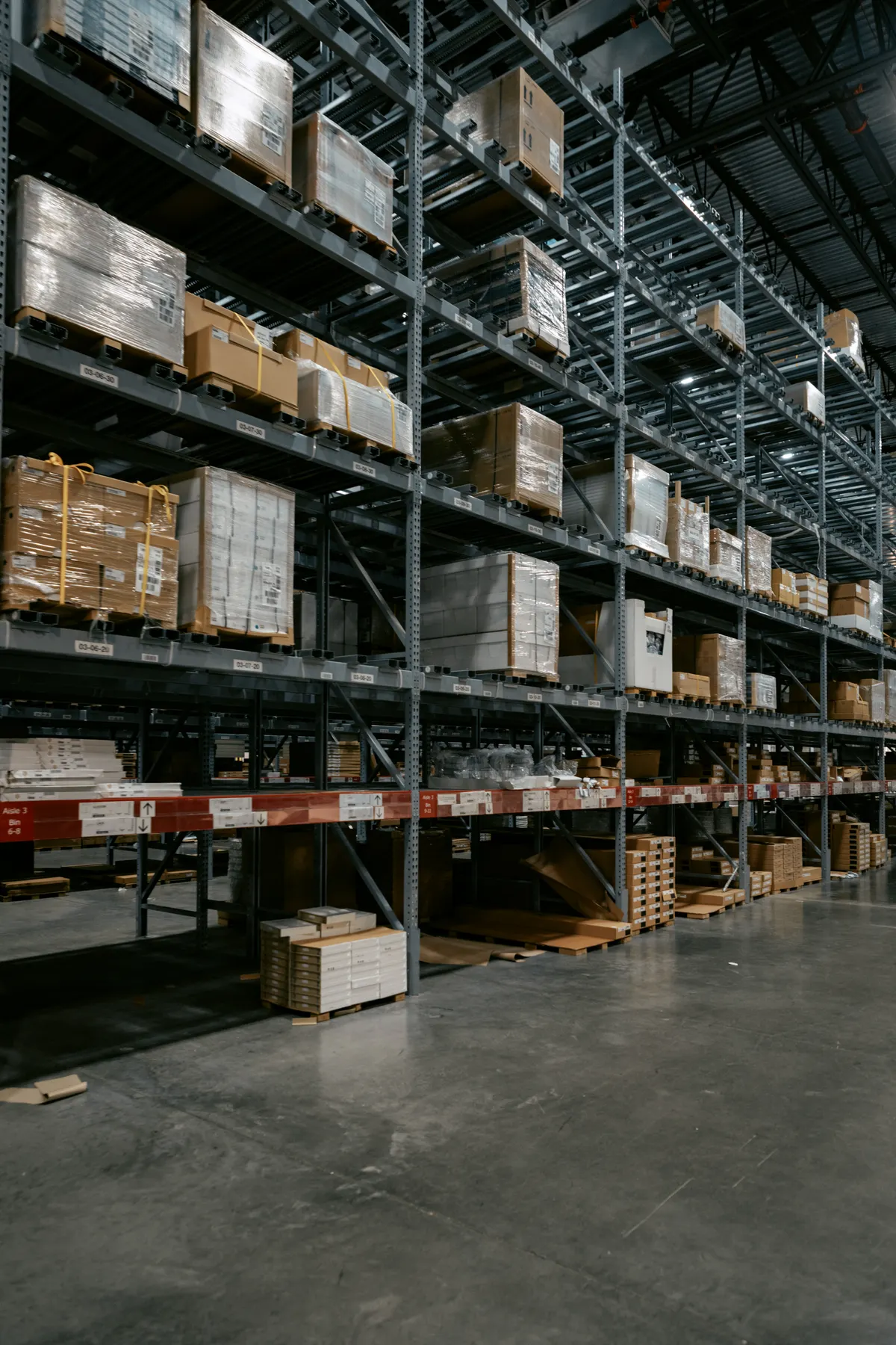 Tall storage racks holding palletized stock in a warehouse aisle